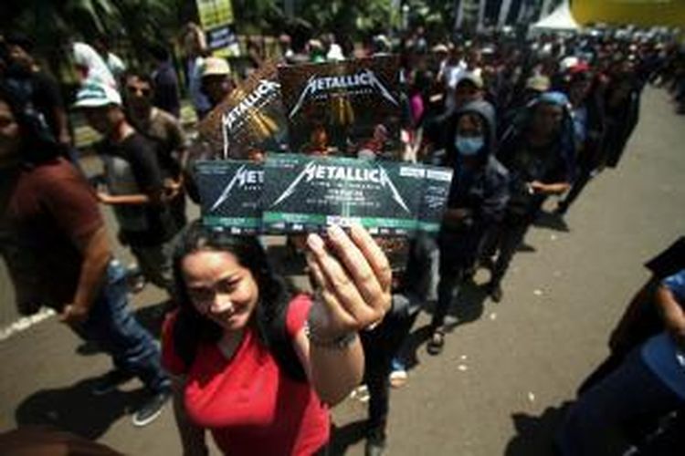 Calon penonton konser Metallica menunjukkan tiket yang telah dibelinya di Stadion Utama Gelora Bung Karno, Senayan, Jakarta, Sabtu (24/8/2013). Band metal asal AS tersebut menggelar konser mereka pada Minggu, 25 Agustus 2013 malam.
