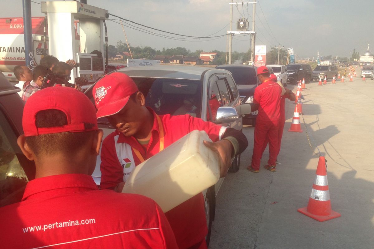 Petugas mengisi BBM ke kendaraan pemudik menggunakan derigen yang berisi 10 liter Pertamina Dex di Rest Area KM 420 tol fungsional Batang-Semarang, Jumat (22/6/2018) sore. 