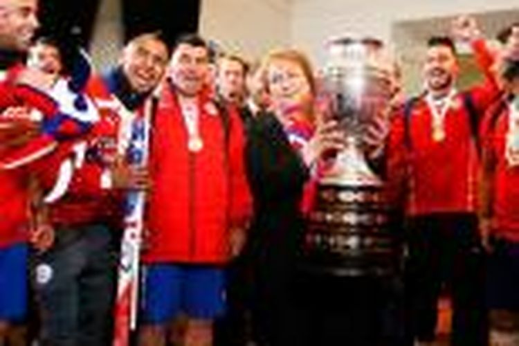 Presiden Cile, Michele Bachelet, memegang trofi Copa America 2015 yang diraih tim nasional negaranya, Sabtu (4/7/2015). 