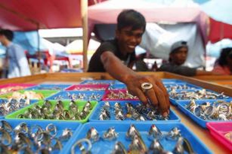 Penjual menata cincin di Pasar Grosir Batu Akik Nusantara, Rawa Bening, Jatinegara, Jakarta, Jumat (7/8/2015). Meskipun tren harga batu akik menurun, penjual mengaku bisnis ini masih bertahan karena peminat dan kebutuhan akan batu akik akan terus ada.