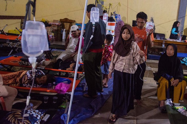 Pasien korban keracunan massal berjalan dengan infus terpasang saat mendapatkan perawatan di Posko Penanganan Kantor Kecamatan Cipongkor, Kabupaten Bandung Barat, Jawa Barat, Jumat (26/9/2025). Sebanyak 17 orang korban kembali mendapatkan perawatan setelah sempat dinyatakan pulih pascakeracunan massal usai mengonsumsi makan bergizi gratis (MBG) pada Senin (22/9) dan Rabu (24/9) lalu. 