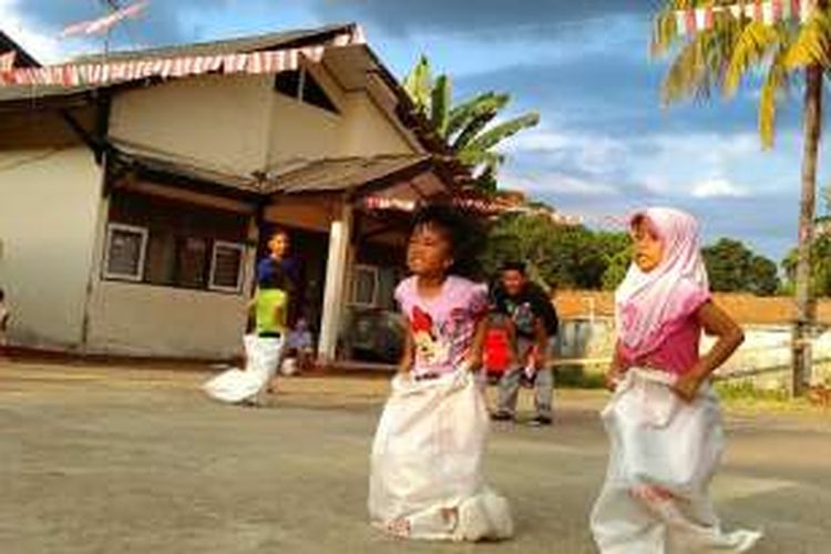 Anak-anak di pengungsian Transito mengikuti lomba balap karung, Selasa (16/8/2016). 