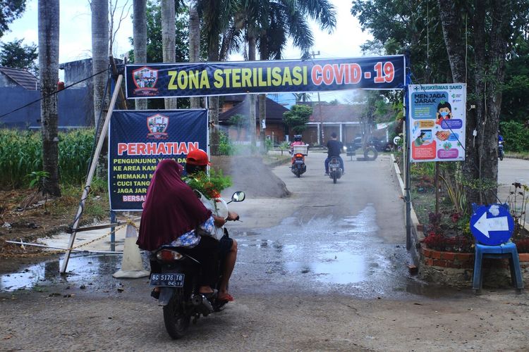 Penyemprotan cairan desinfektan kepada para pengendara ataupun warga yang hendak masuk ke komplek Bumi Sako Damai (BSD), Kecamatan Sako, Palembang, Disini warga diwajibkan mengikuti protokol kesehatan Covid-19.