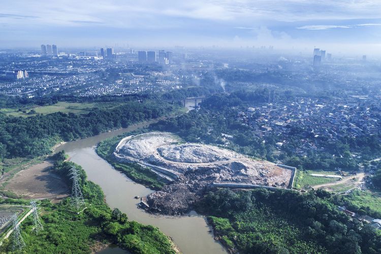 Timbulan sampah dari Tempat Pembuangan Akhir (TPA) Cipeucang longsor dan menimbun sekitar dua pertiga badan Sungai Cisadane di kawasan Serpong, Tangerang Selatan, Banten, Rabu (27/5/2020). TPA Cipeucang yang longsor pada Jumat (22/5/2020) dini hari ini berada sekitar 50 meter di samping Sungai Cisadane. Setiap hari, 300 ton sampah diangkut ke TPA Cipeucang yang beroperasi sejak 2012 dan terbagi atas dua zona, masing-masing seluas 2,5 hektar dan 1,7 hektar.
