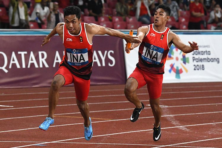 Pelari Indonesia Fadlin (kanan) menyerahkan tongkat kepada Lalu Muhammad Zohri pada babak final Lari Estafet 4x100m Putra Asian Games ke-18 Tahun 2018 di Stadion Utama Gelora Bung Karno Senayan, Jakarta, Kamis (30/8/2018). Lalu Muhammad Zohri, Fadlin, Eko Rimbawan dan Bayu Kertanegara mencatatkan waktu 38,77 detik sekaligus mempersembahkan medali pertama Indonesia dari nomor 4 x 100 meter sejak tahun 1966.