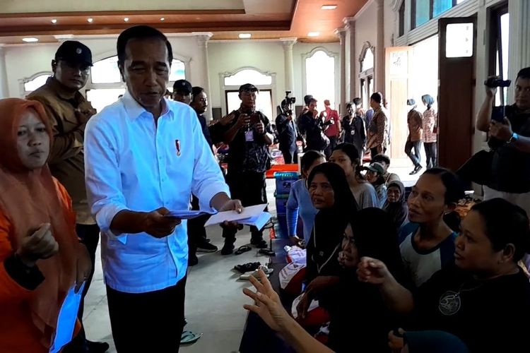 Jokowi nampak membagikan ampolop berisi uang kepada korban banjir Demak di Pos pengungsian Gedung Wisma Halim, Jumat (22/3/2024). 