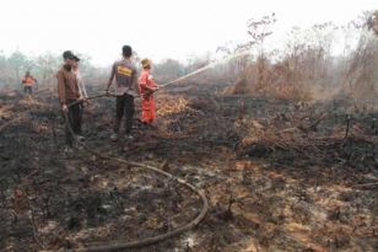 Anggota Manggala Agni Daops Singkawang melakukan pemadaman kebakaran hutan gambut di Desa Telok Ampening, Kecamatan Terentang, Kabupaten Kubu Raya, Kalbar, Jumat (25/9/2015).