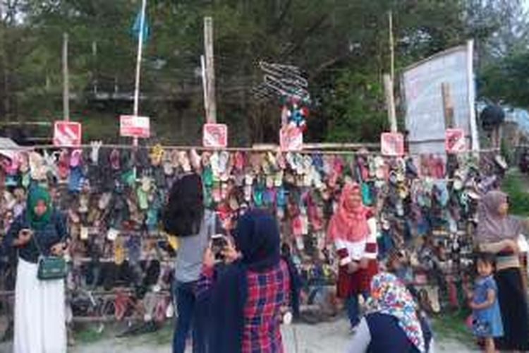 Pengunjung berfoto di 'tembok' sandal di Obyek Wisata Tapak Paderi, Kota Bengkulu.