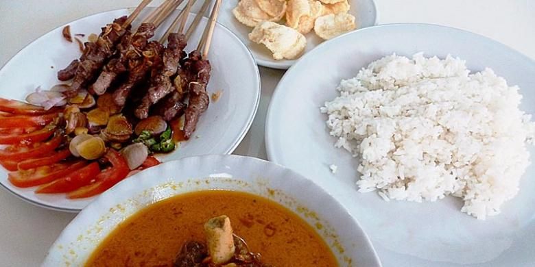 Seporsi sate kambing (10 tusuk), semangkuk gulai kambing, sepiring nasi putih, dan beberapa emping melinjo sebagai menu santap siang di Rumah Makan Sate Pak Rebing, Empang, Bogor Selatan, Kota Bogor.