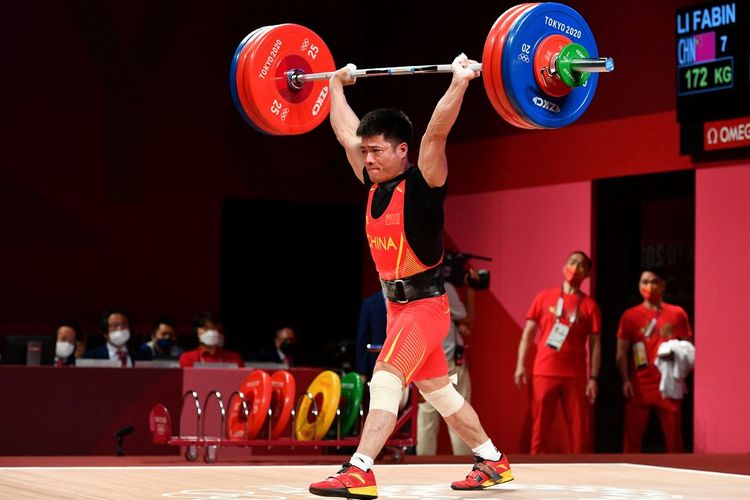 Aksi lifter China Li Fabin yang turun di kelas 61 kilogram putra cabang olahraga angkat besi Olimpiade Tokyo 2020, 25 Juli 2021. 