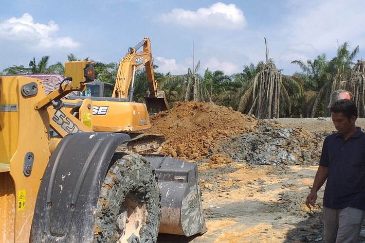 Alat berat membuat sekat di lokasi semburan gas agar lumpur tidak menyebar semakin meluas di kawasan Ponpes IBS Riau Kampus 2 di Kelurahan Tuah Negeri, Kecamatan Tenayan Raya, Kota Pekanbaru, Riau, Rabu (10/2/2021).