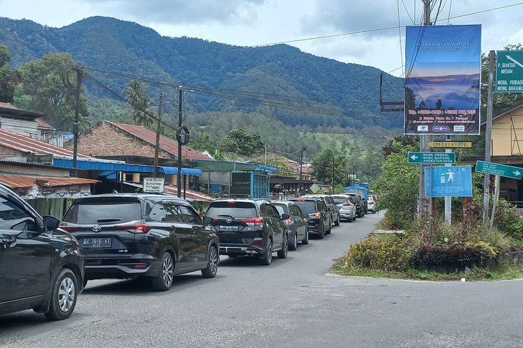 Foto: Kendaraan roda empat mengantri di Jalan Josep Sinaga Kelurahan Parapat, Kabupaten Simalungun, Jumat (6/5/2022). Arus kendaraan tersebut datang dari pelabuhan Kapal Ferry di Kecamatan Ajibata Kabupaten Toba keluar dari Parapat.