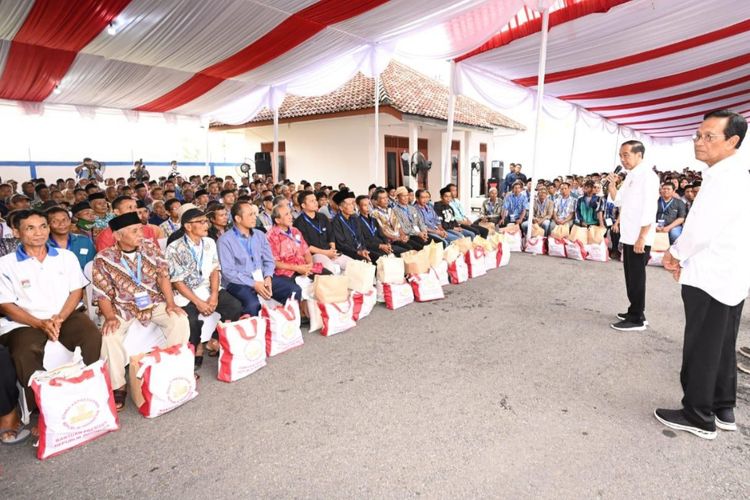 Presiden Joko Widodo bersama Sri Sultan Hamengkubuwono X saat menyerahkan bantuan pangan beras cadangan pangan pemerintah (CBP) kepada masyarakat penerima manfaat di Gudang Bulog Sendangsari, Kabupaten Bantul, Daerah Istimewa Yogyakarta (DIY) pada Selasa (30/1/2024).