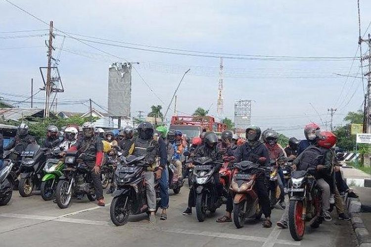 Pengendara sepeda motor sedang berhenti di lampu merah di Jalur Pantura Kota Tegal, Jumat (29/4/2022). 

