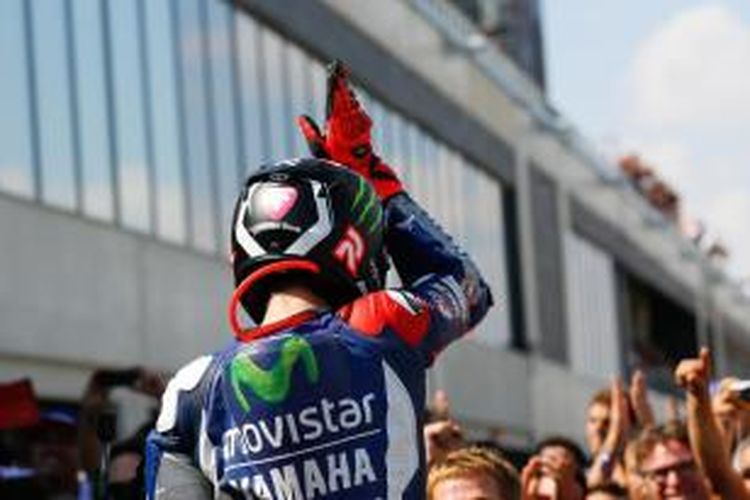 Pebalap Movistar Yamaha asal Spanyol, Jorge Lorenzo, merayakan kemenangan setelah finis pertama pada balapan GP Aragon di Sirkuit MotorLand, Minggu (27/9/2015).