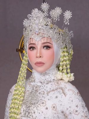 Melly Goeslaw tampil anggun dengan kebaya putih, siger megah, dan ronce melati di perayaan 30 tahun pernikahan, kental nuansa adat Sunda.