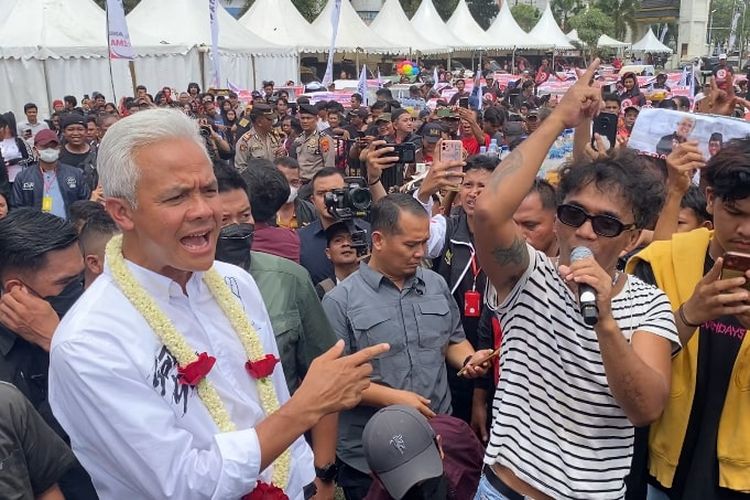 Vokalis Slank, Kaka (kanan) berjoget bersama calon presiden (capres) nomor urut 3 Ganjar Pranowo (kiri) menghadiri kampanye akbar bertajuk Hajatan Rakyat di Istana Maimun, Medan, Sumatera Utara, Minggu (28/1/2024) siang.