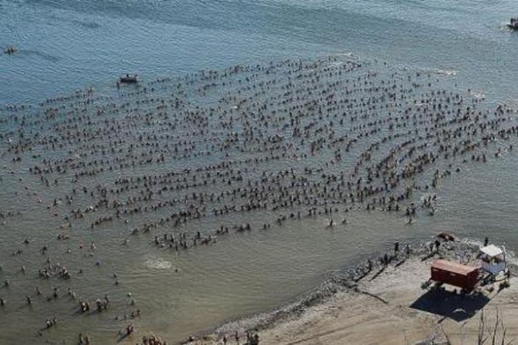 Hampir 2.000 orang ambil bagian dalam upaya pemecahan rekor dunia membentuk rantai manusia yang mengambang di air, di sebuah danau air asin di Argentina, Minggu.  
