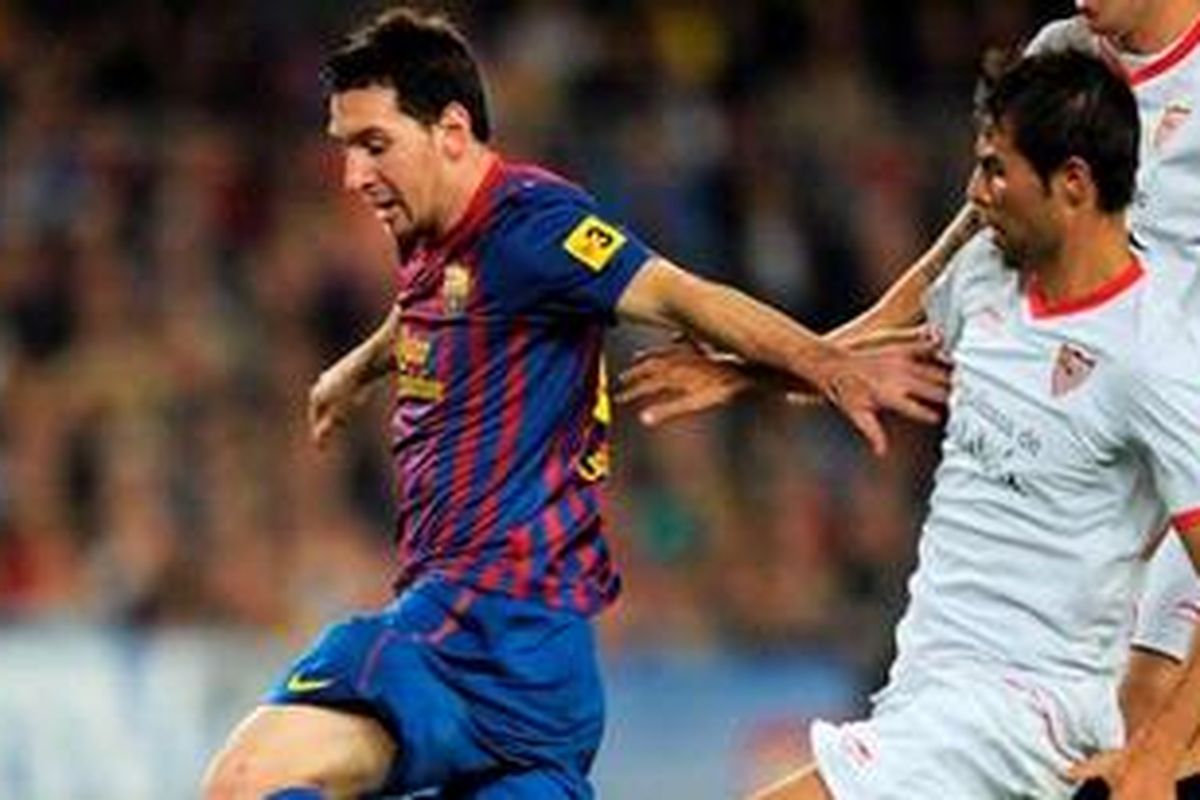 Striker Barcelona, Lionel Messi, dihadang derdefen Sevilla, Coke Andujar (kanan), pada pertandingan Liga BBVA, Sabtu atau Minggu (23/10/2011) dini hari WIB. Barcelona ditahan Sevilla 0-0 dan gagal kembali ke puncak klasemen.