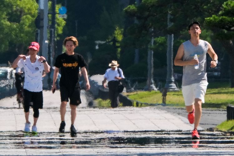 Sejumlah masyarakat Tokyo terlihat beraktivitas di tengah gelombang panas, di sekitar Imperial Palace, Tokyo, (29/06/2022). Jepang mengalami suhu ektrem dalam beberapa hari terakhir, dengan beberapa daerah mencapai suhu di atas 40 derajat Celcius.