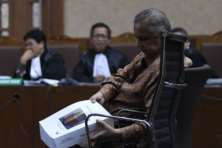 Terdakwa kasus dugaan suap proyek PLTU Riau-1, Sofyan Basir (kanan) menerima salinan berkas tuntutan dari Jaksa Penuntut Umum (JPU) saat persidangan di Pengadilan Tipikor, Jakarta, Senin (7/10/2019). Mantan Dirut PLN tersebut dituntut hukuman lima tahun penjara dengan denda Rp200 juta subsider tiga bulan penjara. ANTARA FOTO/Puspa Perwitasari/aww.
