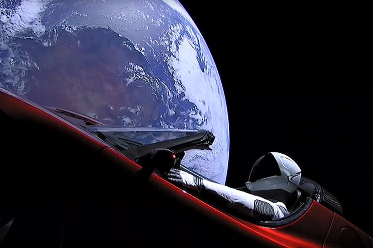 Gambar yang diambil dari video livestream ini menunjukkan manekin bernama Starman duduk di mobil sport Tesla milik Elon Musk yang dibawa roket Falcon Heavy melintasi luar angkasa, Selasa (6/2/2018) waktu setempat. Roket yang diklaim paling kuat di dunia itu memiliki tenaga pendorong setara dengan 18 pesawat Boeing 747, dan diketahui mampu mengirim muatan berat seperti satelit untuk pemerintah dan berbagai perusahaan swasta.