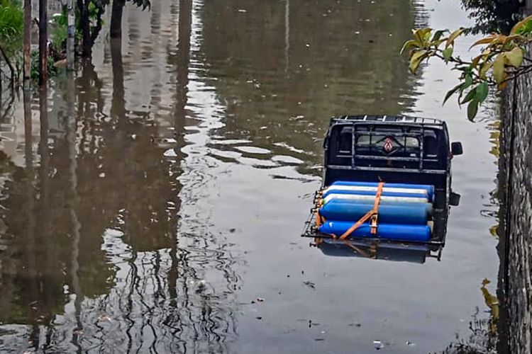 Sebuah mobil bak pengangkut tabung oksigen terjebak di tengah genangan banjir Jalan Raya Cimindi, Kota Cimahi, Jawa Barat, Jumat (24/2/2023).