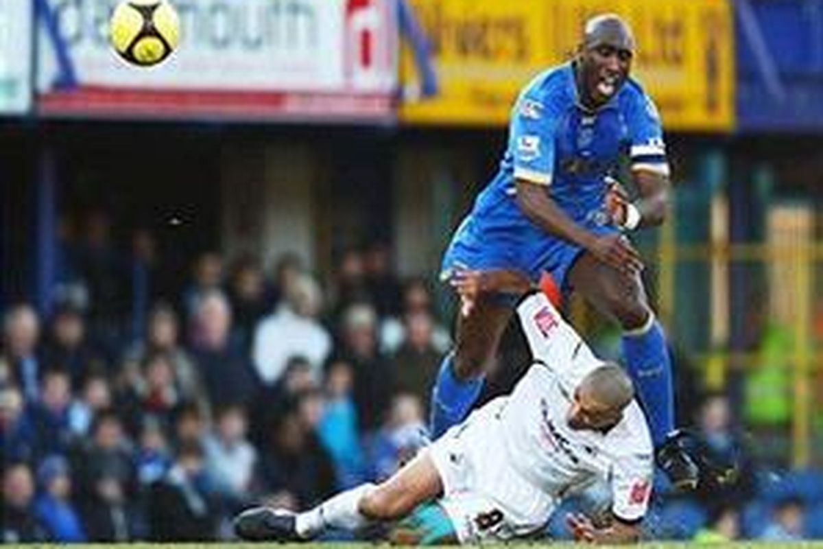 Bek Portsmouth Sol Campbell (kanan), berusaha menghindar dari pemain Swansea City, Darren Pratley. Pada pertandingan putaran keempat Piala FA ini, Portsmouth yang merupakan juara bertahan ini kalah 0-2 dan tersingkir.