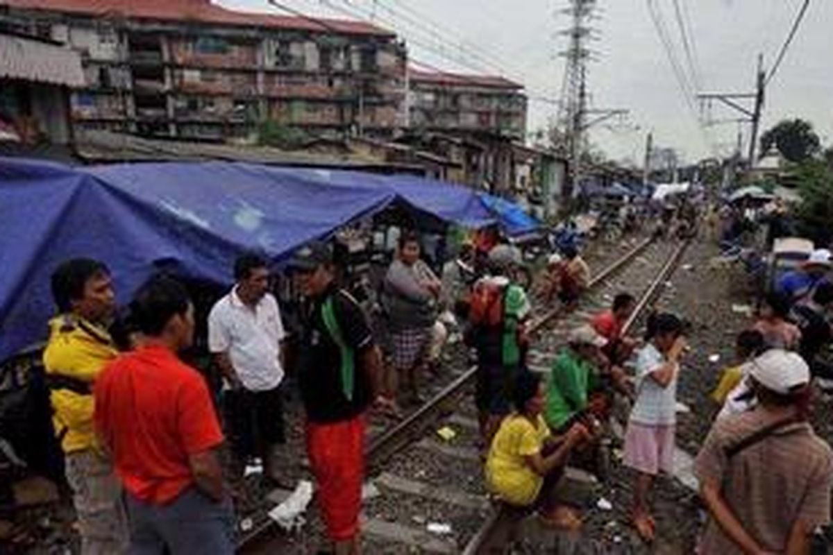 Terhentinya operasional kereta api karena banjir dimanfaatkan warga kawasan Bongkaran, Tanah Abang, Jakarta, untuk menjadi tempat pengungsian, Jumat (18/1/2013). Kawasan rel kereta dijadikan pengungsian karena letaknya lebih tinggi daripada permukiman mereka yang kebanjiran.