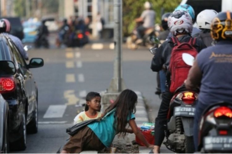 Anak-anak mengemis di Jalan Diponegoro, Kota Pekanbaru, Riau, beberapa hari lalu.