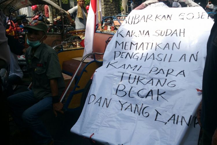 Salah satu poster yang dibawa para abang becak saat aksi unjuk rasa penolakan ojek online di Balai Kota Kediri, Jawa Timur, Selasa (10/10/2017).