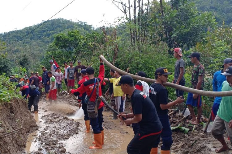 Petugas gabungan SAR melakukan kerja bakti membersihkan material longsor yang menutup akses jalan di Desa Kalirejo, Kecamatan Salaman, Kabupaten Magelang, Senin (18/3/2019).