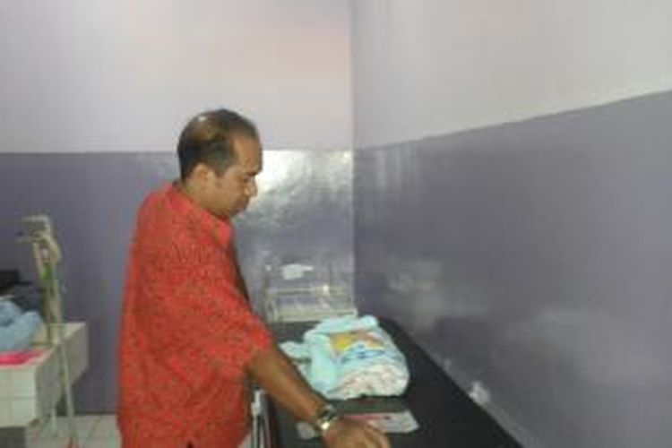 Seorang petugas medis RS dr Haulussy Ambon terlihat menaruh jenazah bayi Yusuf Tewernussa di kamar mayat rumah sakit itu, Jumat (19/9/2014). Yusuf meninggal pada pukul 02.30 Wit dini hari tadi 