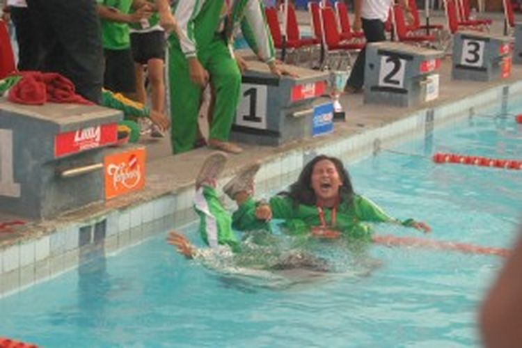 Dua anggota tim putri UNJ yang masih mengenakan pakaian lengkap, mendapat kehormatan diceburkan ke kolam oleh rekannya usai penyerahan penghargaan Liga Mahasiswa (LIMA) Swimming 2013 di Kolam Renang Pertamina, Simprug, Jakarta Selatan, Minggu (30/6/2013).