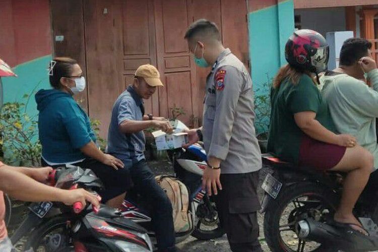 Tim Dokkes Polda Sulut bagikan masker kepada warga yang berada di seputaran lokasi pengungsian di Pulau Tagulandang, Jumat (19/4/2024).
