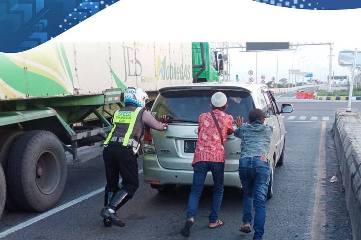 Bripka Bambang, anggota Satlantas Polres Gresik saat membantu mendorong mobil yang mogok di exit tol Kebomas, Minggu (1/11/2020).