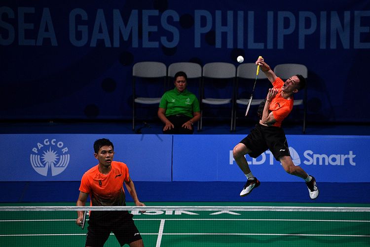 Ganda putra Indonesia Muhammad Rian Ardianto (kanan) dan Fajar Alfian mengembalikan kok ke arah ganda putra Malaysia Aaron Chia Teng Fong dan Soh Wooi Yik dalam final bulu tangkis beregu putra SEA Games 2019 di Kompleks Olahraga Muntinlupa, Manila, Filipina, Rabu (4/12/2019). Tim bulu tangkis beregu putra Indonesia meraih medali emas setelah mengalahkan Malaysia dengan skor 3-1.