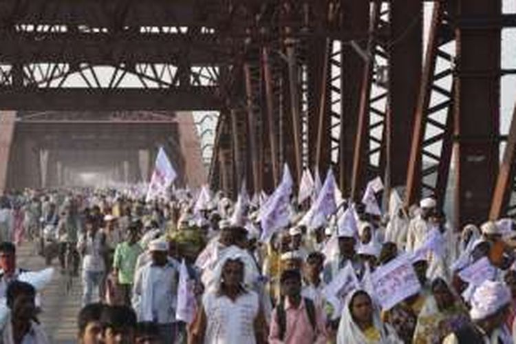 Ilustrasi: Peziarah Hindu membawa bendera-bendera keagamaan dan berjalan di jembatan yang padat orang.