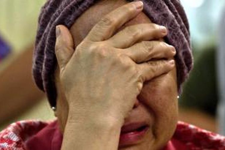 Akmar Binti Mohd Noor (67) menangis saat mengetahui saudara perempuannya ada dalam pesawat Malaysia Airlines MH17 yang jatuh di Ukraina, Kamis (17/7/2014).