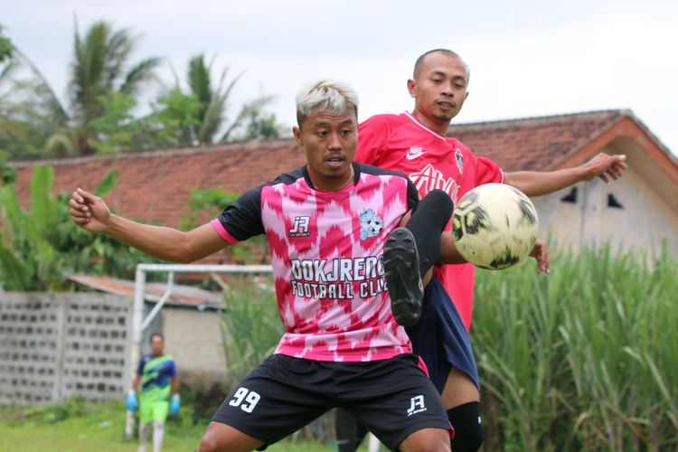 Pemain Arema FC Kushedya Hari Yudo dijaga ketat lawan saat pertandingan laga amal nutuk korban bencana di Sulawesi dan Kalimantan di Lapangan Desa Dampit, Kabupaten Malang, Jawa Timur, Minggu (24/01/2021) sore.