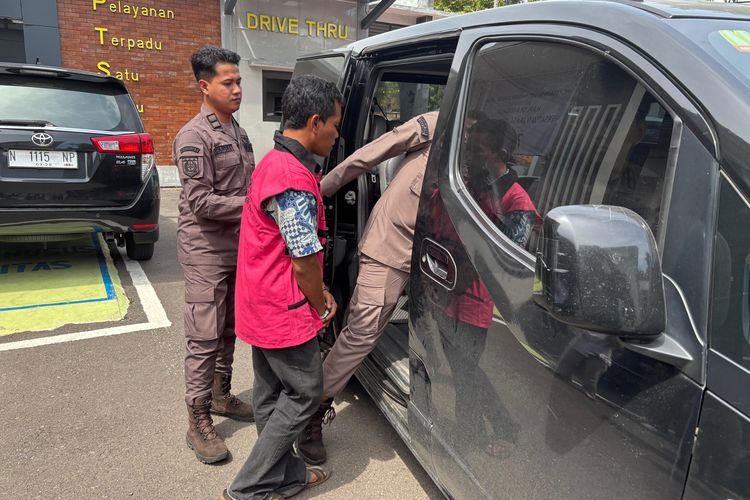 AW (rompi pink) memasuki mobil menuju rumah tahanan Kraksaan. 
