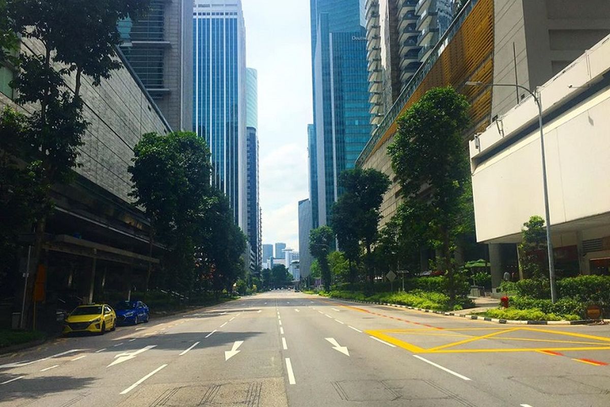 Jalan raya Shenton Way di kawasan distrik bisnis Tanjong Pagar, Singapura terlihat lenggang, Senin siang (18/05/2020). Jalanan Singapura memang terlihat lebih sunyi di mana hanya ada segelintir kendaraan yang melintas sejak lockdown parsial atau circuit breaker diberlakukan pada 7 April lalu. Singapura akan mencabut lockdown parsial pada 1 Juni mendatang