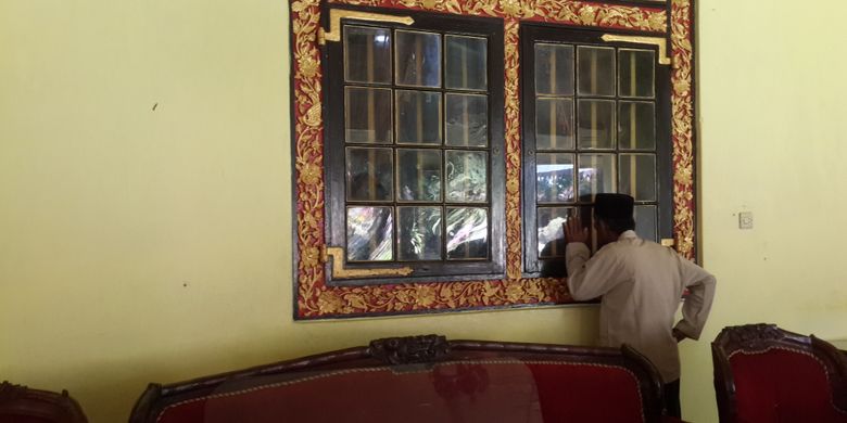 Seorang wisatawan saat mengintip kamar tidur raja-raja Sumenep dari balik jendela kaca di Keraton Sumenep, Minggu (2/7/2017). Ruangan tersebut tidak boleh dimasuki oleh wisatawan. Wisatawan hanya bisa mengintip dari balik jendela kaca.