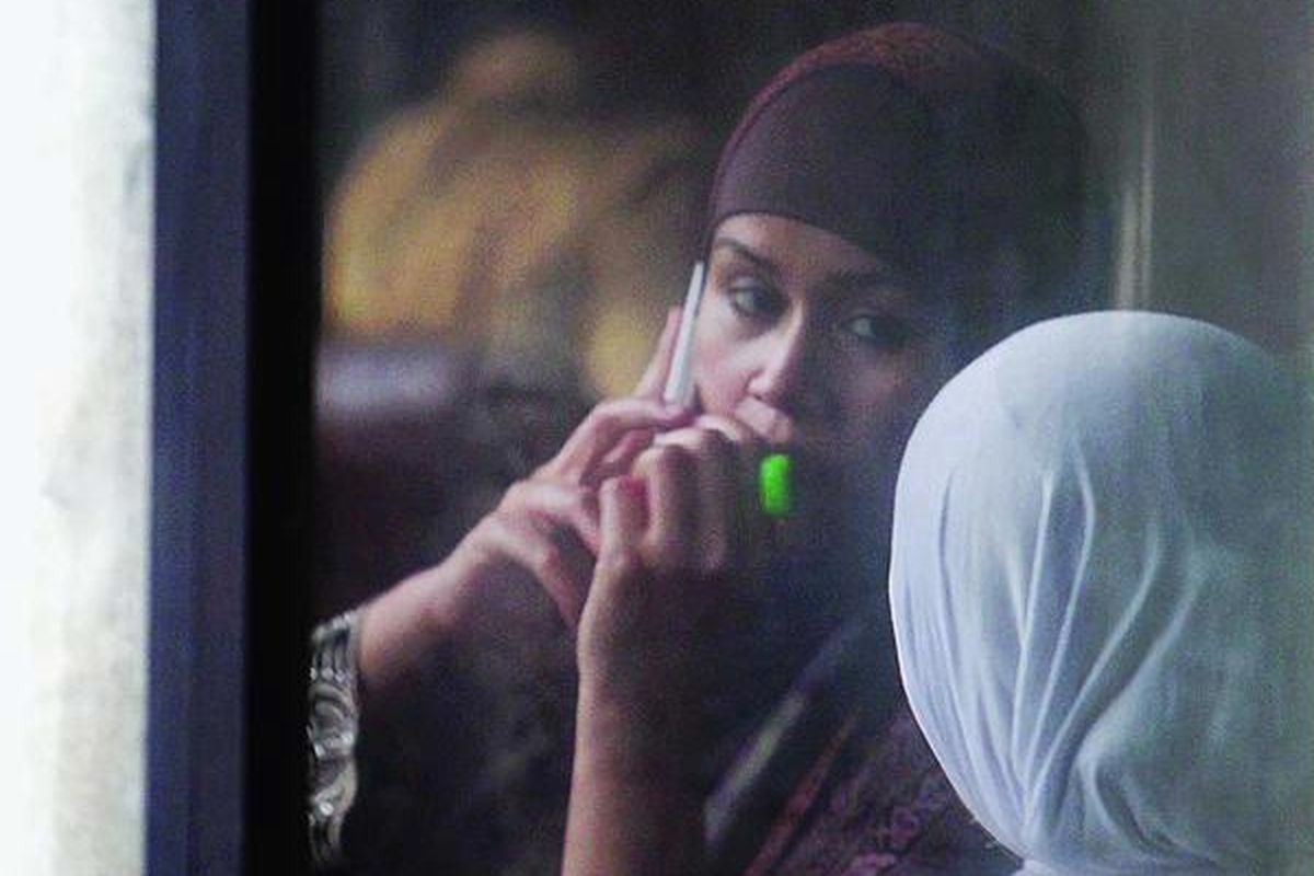 Neneng Sri Wahyuni, terdakwa dugaan tindak pidana korupsi terkait proyek pengadaan pembangkit listrik tenaga surya di Kementerian Tenaga Kerja dan Transmigrasi pada tahun 2008, menelepon seusai sidang di Pengadilan Tindak Pidana Korupsi Jakarta, Selasa (13/11). Sidang itu mengagendakan tanggapan jaksa yang menolak eksepsi Neneng.