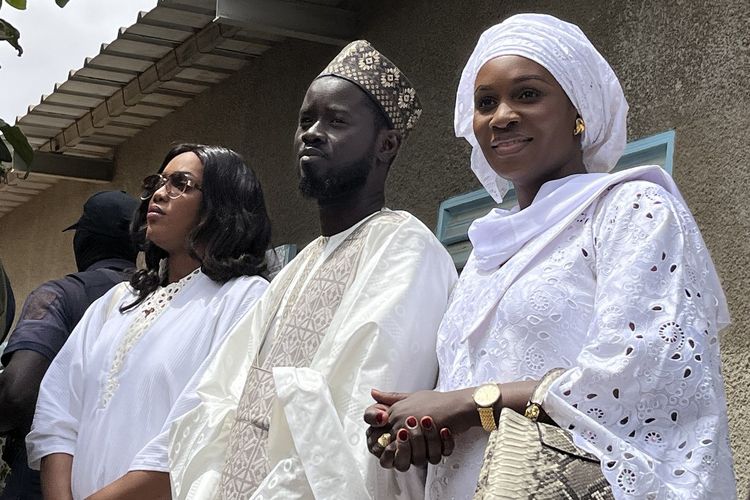 Presiden baru Senegal Bassirou Diomaye Faye (tengah) dan istrinya, Marie Khone Faye (kiri) serta Absa Faye (kanan) setelah menggunakan hak pilih mereka di TPS Ecole Ndiandiaye di Ndiaganiao, 24 Maret 2024.
