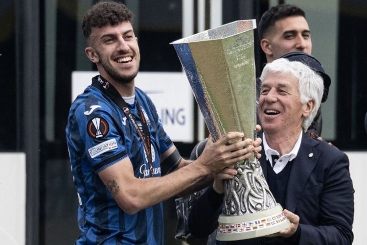 Bek Atalanta Matteo Ruggeri (kiri) dan pelatih Atalanta asal Italia Gian Piero Gasperini (kanan) memegang trofi saat tim tiba di bandara Bergamo, satu hari setelah memenangkan final Liga Eropa UEFA di Bergamo pada 23 Mei 2024.