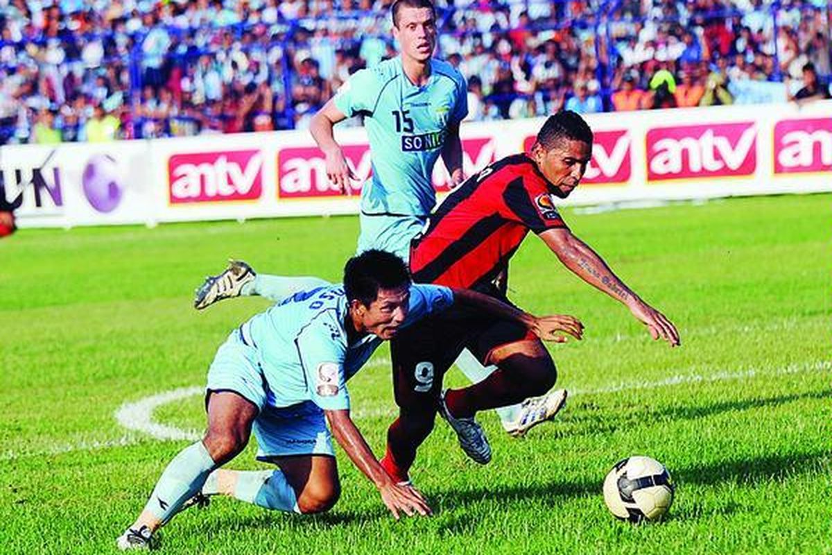 Pemain Persipura Jayapura, Victor Pae (kanan), berebut bola dengan pemain Persela Lamongan, Suroso, dalam Liga Super Indonesia di Stadion Surajaya, Lamongan, Jawa Timur, Rabu (28/3). Pertandingan berakhir imbang 0-0.