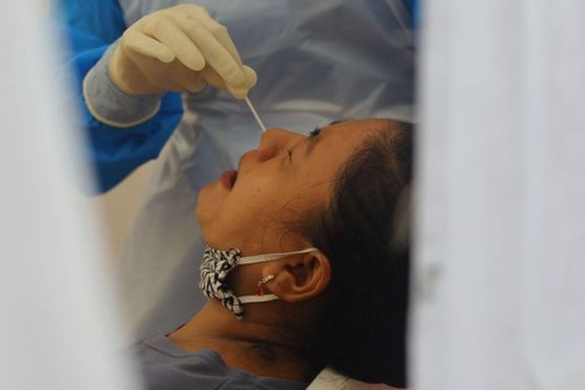 Petugas kesehatan mengambil sampel lendir dari hidung salah satu warga saat mengikuti swab test dan tes diagnostik cepat (rapid test) COVID-19 secara massal di Surabaya, Jawa Timur, Senin (1/6/2020). 