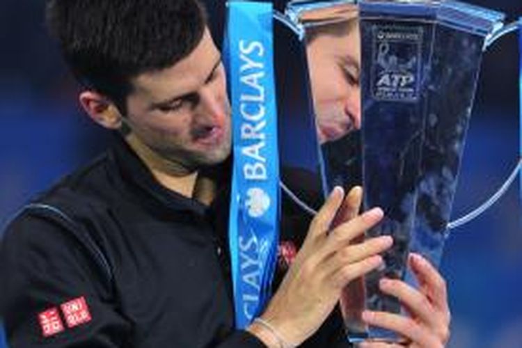 Petenis Serbia, Novak Djokovic memeluk trofi Brad Drewett setelah mengalahkan petenis Spanyol, Rafael Nadal, pada laga final ATP World Tour Finals di O2 Arena, London, Senin (11/11/2013). Djokovic menang 6-3, 6-4. 