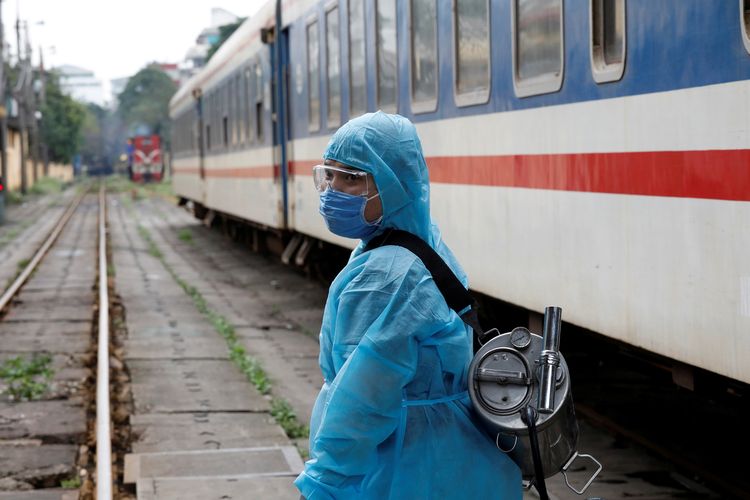 Seorang petugas medis Vietnam sedang menyemprotkan disinfektan ke kereta api, sebagai tindakan untuk membasmi wabah virus corona. Gambar diambil di Hanoi, Vietnam, 19 Maret 2020.